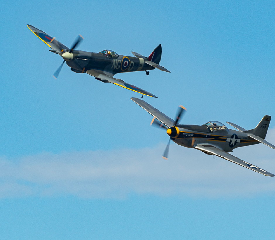 Tv&aring; stridsflygplan av &auml;ldre modell flyger. Himlen &auml;r bl&aring;.