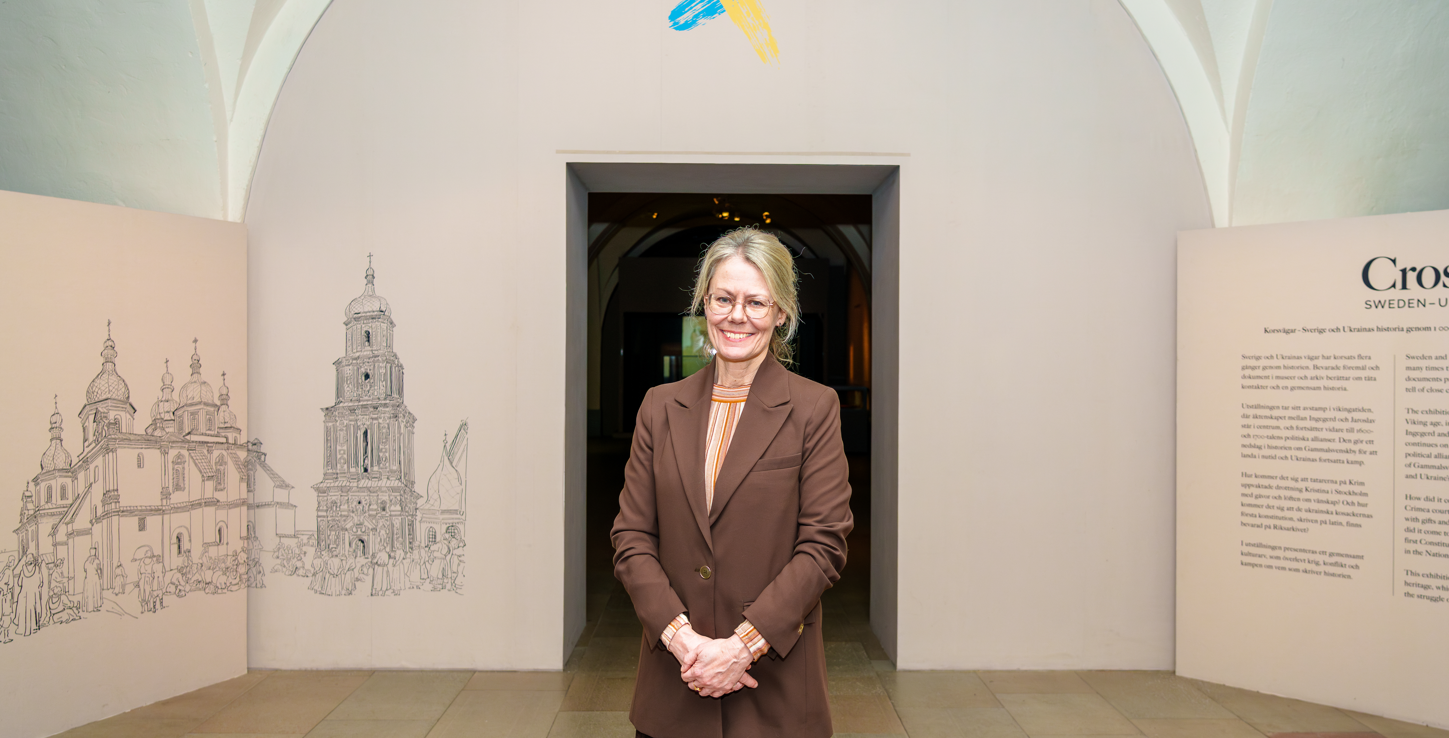 Helene Rånlund står framför utställningen Korsvägar om Ukraina och Sveriges gemensamma historia.