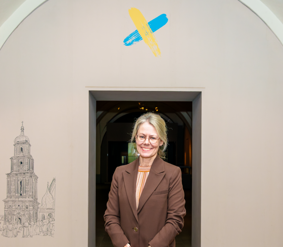 Helene R&aring;nlund st&aring;r framf&ouml;r utst&auml;llningen Korsv&auml;gar om Ukraina och Sveriges gemensamma historia.