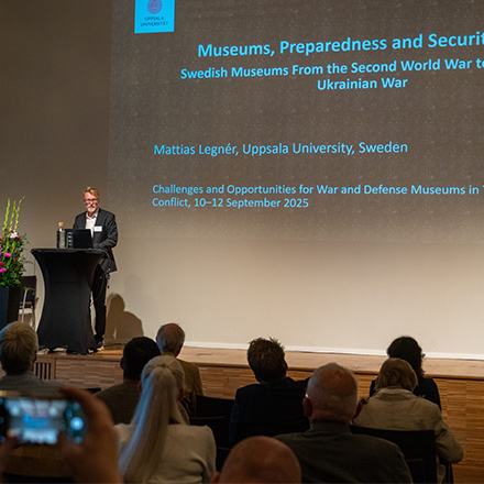 Mattias L&eacute;gner st&aring;r p&aring; podiet och f&ouml;rel&auml;ser framf&ouml;r en samling m&auml;nniskor.
